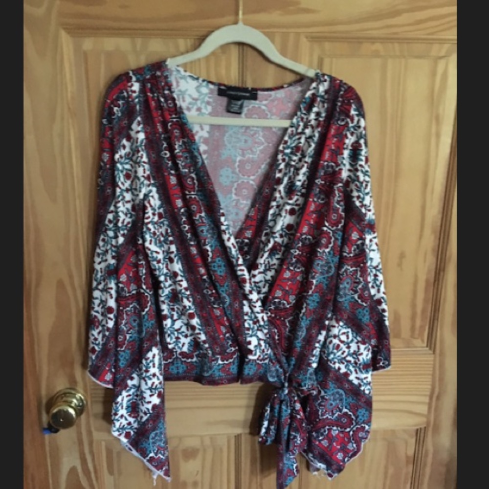 Waist length faux wrap, bell slit sleeved shirt .